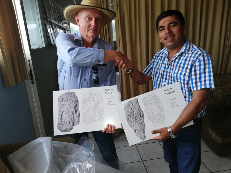 two men holding signage and shaking hands